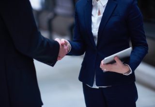 partnership concept with business man and woman hand shake and take agreement in modern office interior